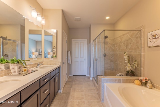 16417 W Piccadilly Rd, Goodyear, AZ 85395 - bathroom featuring double vanity, a stall shower, a bath, and baseboards