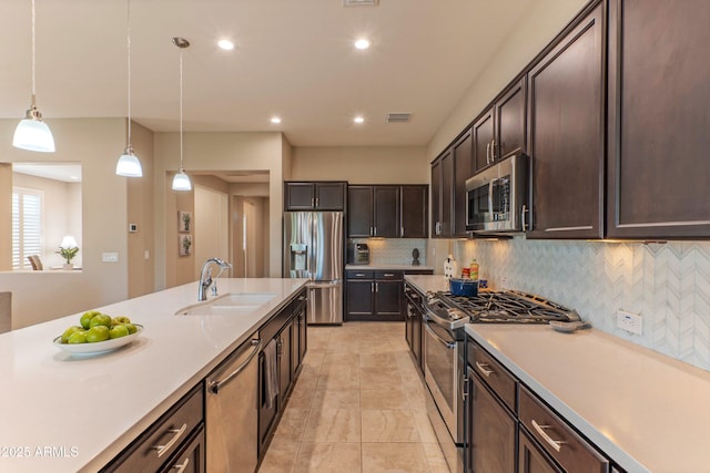 16417 W Piccadilly Rd, Goodyear, AZ 85395 - kitchen featuring stainless steel appliances, a sink, dark brown cabinets, light countertops, and recessed lighting