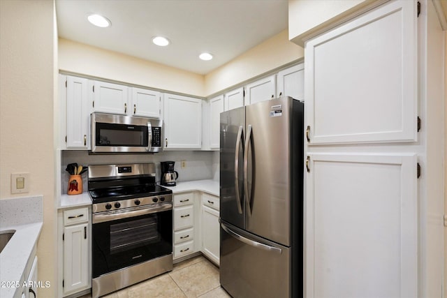 kitchen with light tile patterned flooring, white cabinets, and appliances with stainless steel finishes