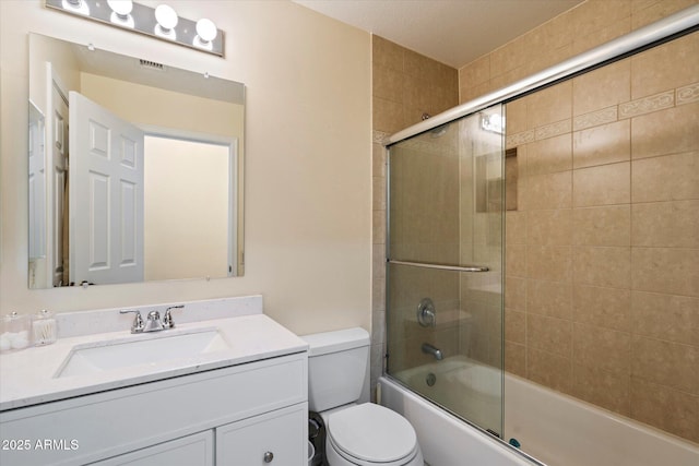 full bathroom featuring vanity, toilet, and combined bath / shower with glass door