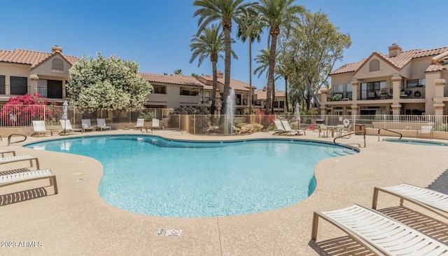 view of swimming pool featuring a hot tub and a patio area