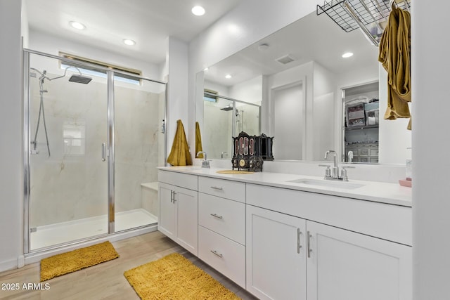 bathroom with vanity, hardwood / wood-style flooring, and a shower with shower door