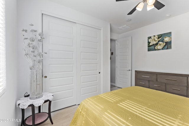 bedroom with ceiling fan, light hardwood / wood-style floors, and a closet