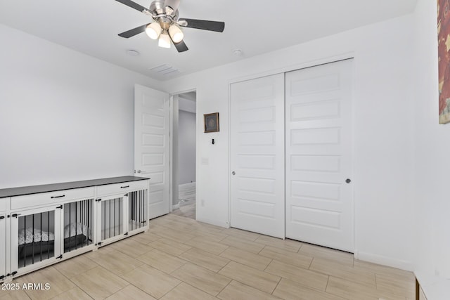 unfurnished bedroom with ceiling fan and a closet