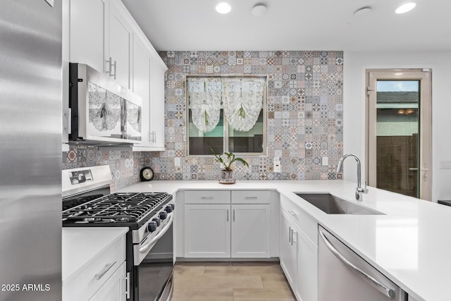 kitchen with white cabinetry, sink, decorative backsplash, and appliances with stainless steel finishes