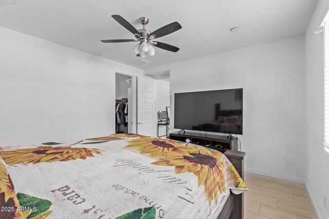 bedroom featuring a walk in closet, ceiling fan, and a closet