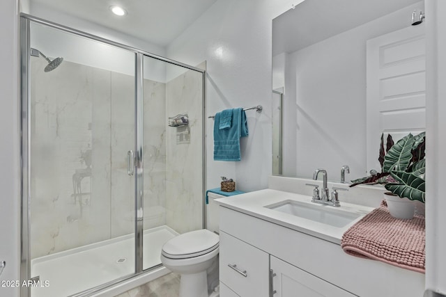 bathroom featuring vanity, toilet, and a shower with door