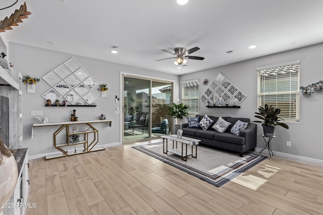 living room with ceiling fan, a healthy amount of sunlight, and light wood-type flooring