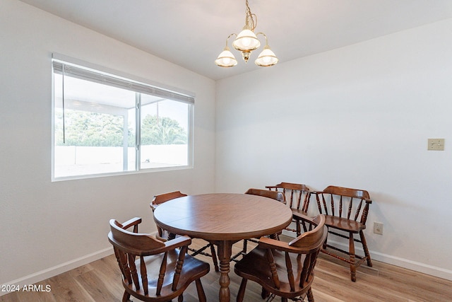 dining area with an inviting chandelier and light hardwood / wood-style floors