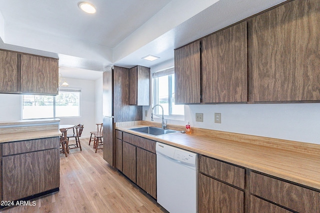 kitchen featuring light wood-style flooring, light countertops, a sink, and dishwasher