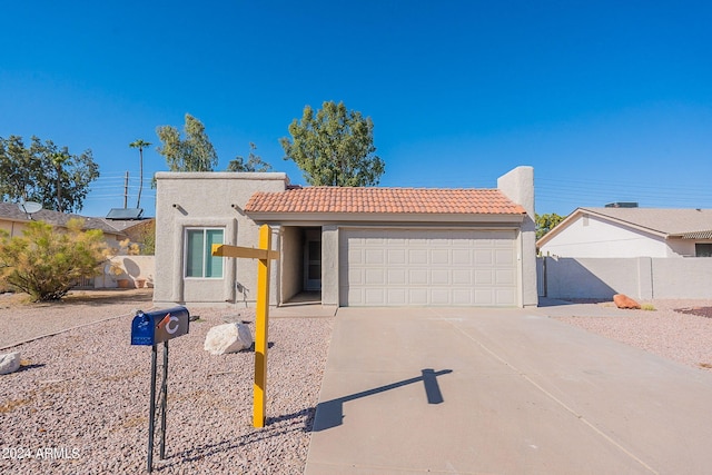 view of front of property featuring stucco siding, an attached garage, a tiled roof, and concrete driveway