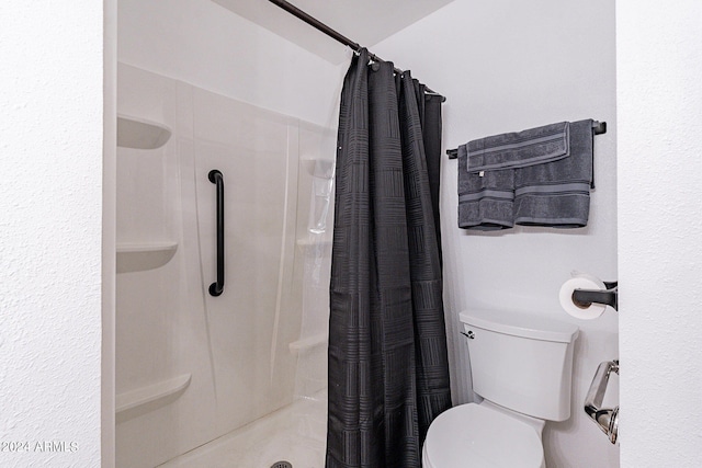 full bathroom featuring toilet and a shower stall