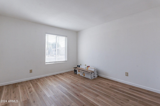 empty room with baseboards and wood finished floors