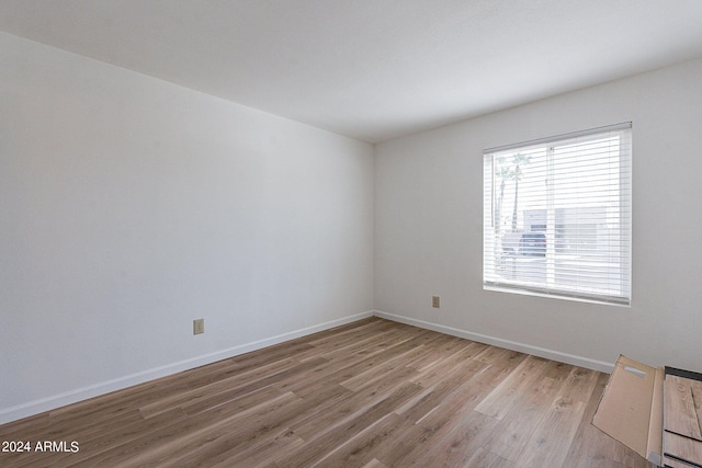 empty room with baseboards and light wood-style flooring