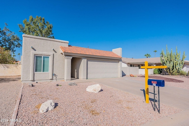 view of front of home with fence, a garage, stucco siding, a tile roof, and driveway