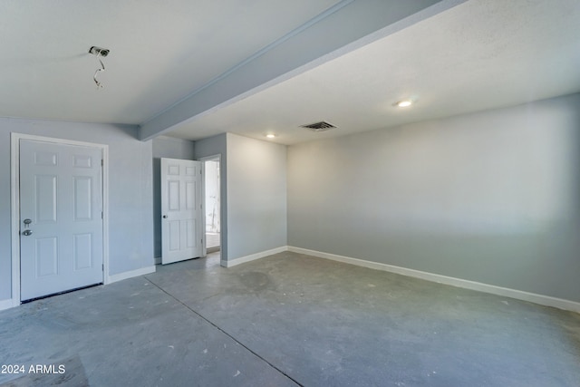 unfurnished room featuring beam ceiling and concrete flooring