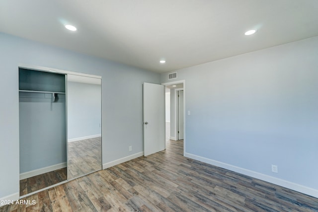 unfurnished bedroom featuring dark wood-type flooring and a closet