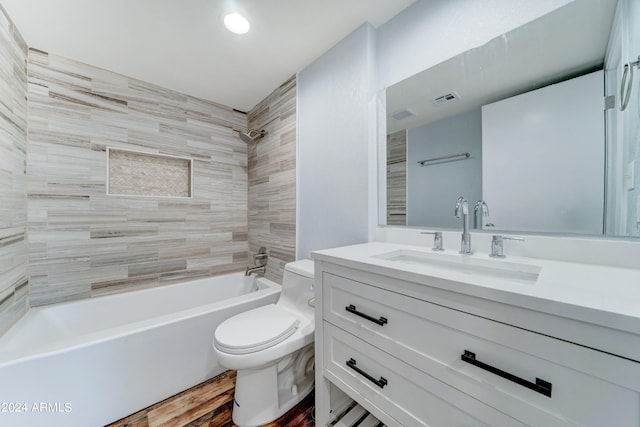 full bathroom featuring vanity, tiled shower / bath combo, wood-type flooring, and toilet