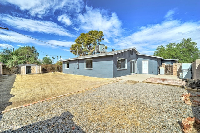 view of side of home with central air condition unit, a patio area, and a storage shed