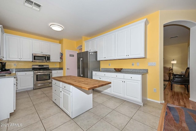 11580 N 86th Ln, Peoria, AZ 85345 - kitchen with appliances with stainless steel finishes, butcher block countertops, arched walkways, and white cabinetry