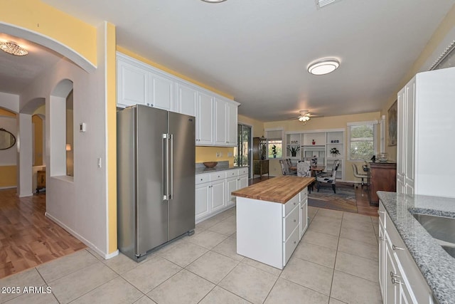 11580 N 86th Ln, Peoria, AZ 85345 - kitchen with high quality fridge, butcher block countertops, arched walkways, white cabinetry, and a ceiling fan
