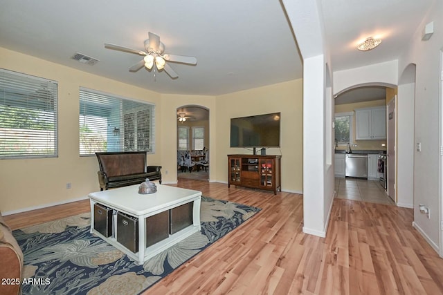 11580 N 86th Ln, Peoria, AZ 85345 - living room featuring arched walkways, a ceiling fan, and light wood-type flooring