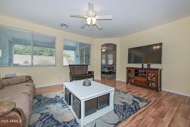 11580 N 86th Ln, Peoria, AZ 85345 - living area featuring ceiling fan, healthy amount of natural light, light wood-style flooring, and arched walkways