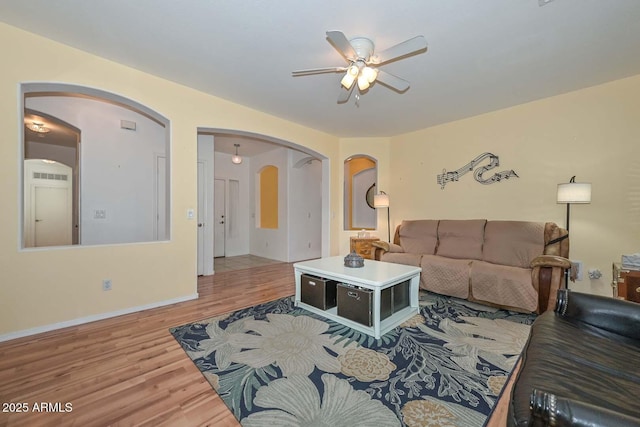 11580 N 86th Ln, Peoria, AZ 85345 - living room with arched walkways, a ceiling fan, and wood finished floors