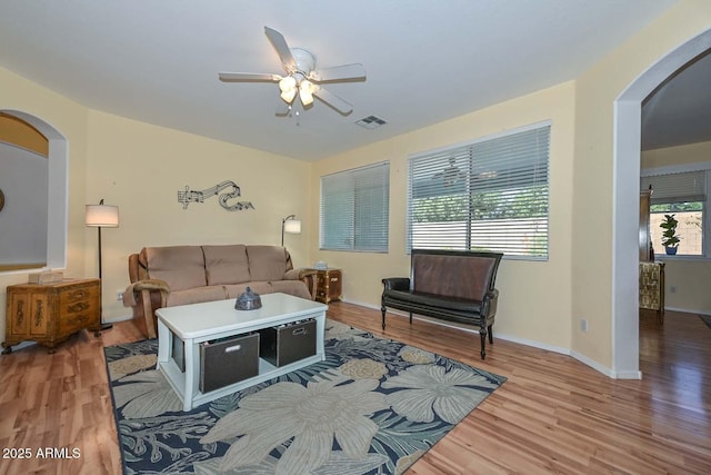 11580 N 86th Ln, Peoria, AZ 85345 - living area with arched walkways, ceiling fan, and light wood-style floors