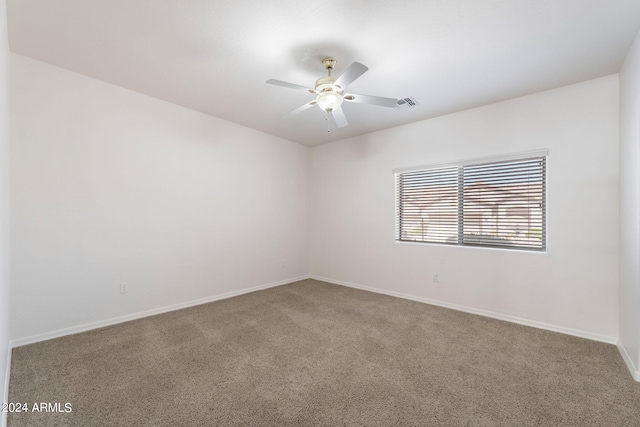 carpeted spare room with ceiling fan