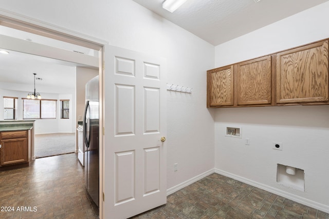 clothes washing area featuring hookup for an electric dryer, a notable chandelier, cabinets, and hookup for a washing machine