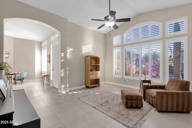 living area featuring lofted ceiling, light tile patterned flooring, plenty of natural light, and ceiling fan