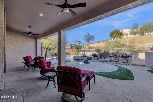 view of patio / terrace with a bar, a fenced in pool, and ceiling fan