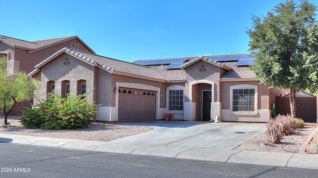 mediterranean / spanish home with a garage and solar panels