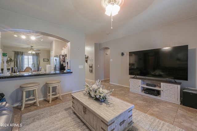 tiled living room with ceiling fan