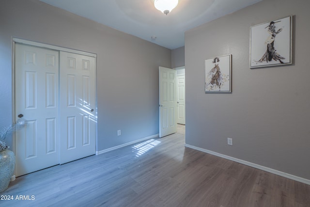 unfurnished bedroom with light hardwood / wood-style flooring, ceiling fan, and a closet