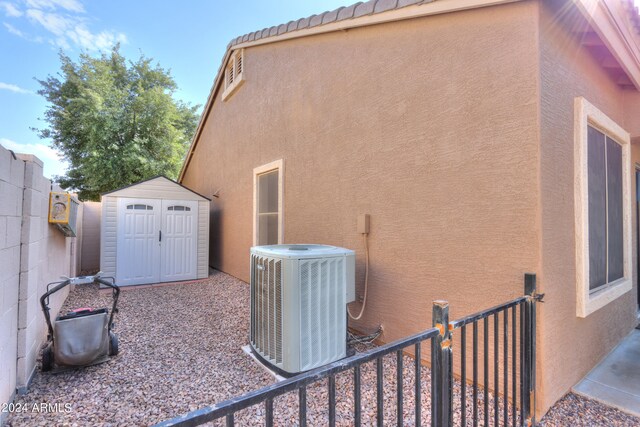 view of side of home featuring a storage shed and central AC