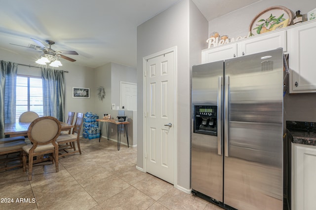 kitchen with dark stone countertops, white cabinetry, ceiling fan, stainless steel refrigerator with ice dispenser, and light tile patterned flooring