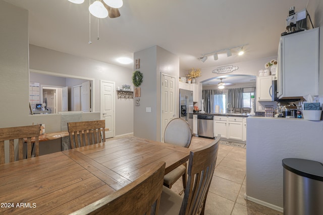 tiled dining room with ceiling fan and sink