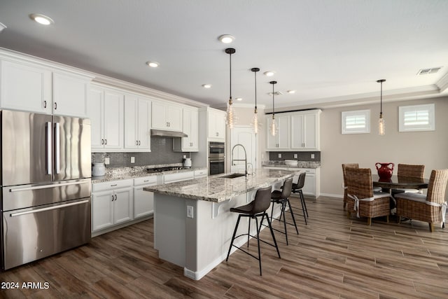 kitchen featuring stainless steel appliances, a kitchen island with sink, dark hardwood / wood-style flooring, and white cabinetry