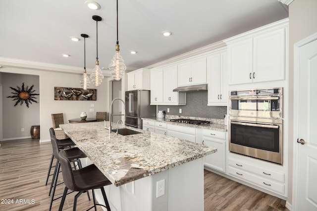 kitchen with an island with sink, hardwood / wood-style flooring, and white cabinetry