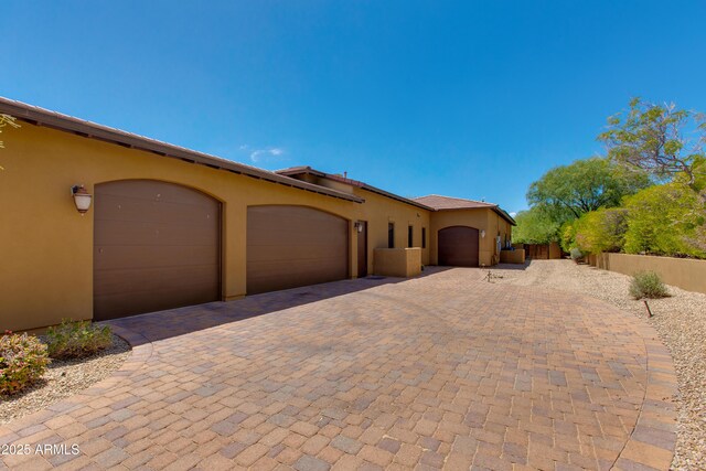 26156 N 88th Way, Scottsdale, AZ 85255 - view of front of house featuring an attached garage, stucco siding, decorative driveway, and fence
