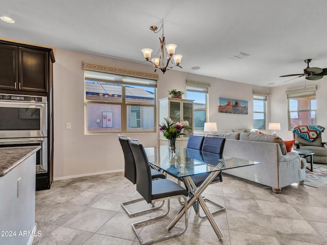 dining space featuring light tile patterned floors and ceiling fan with notable chandelier