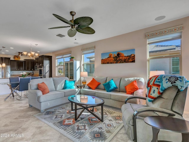 living room with ceiling fan with notable chandelier