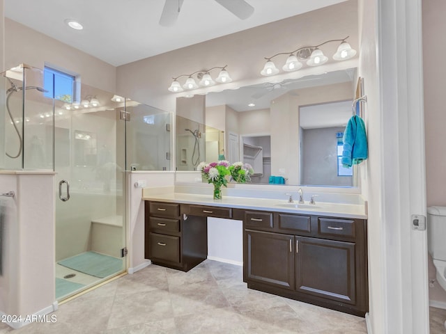 bathroom featuring ceiling fan, tile patterned flooring, toilet, a shower with door, and vanity