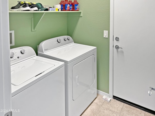 clothes washing area featuring washing machine and dryer and light tile patterned floors