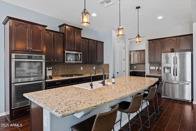 6788 S Jacqueline Way, Gilbert, AZ 85298 - kitchen featuring dark brown cabinetry, visible vents, appliances with stainless steel finishes, a sink, and backsplash