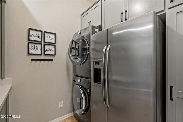 6788 S Jacqueline Way, Gilbert, AZ 85298 - washroom featuring stacked washer and clothes dryer, baseboards, tile patterned floors, and cabinet space