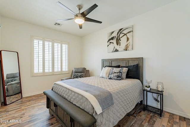 bedroom with ceiling fan, dark wood-type flooring, visible vents, and baseboards