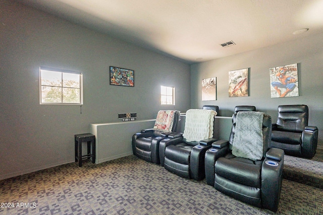 cinema room featuring lofted ceiling, carpet floors, and visible vents